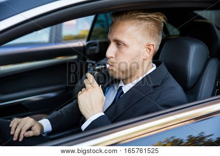 Man Sitting Inside Car Taking Alcohol Test