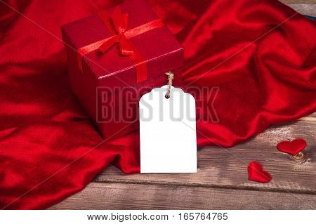 Wrapped red gift box  and gift card on the wooden table can use on valentine day mother day or celebrate love day .