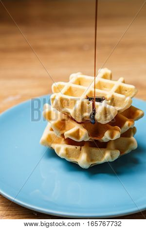 Homemade waffles sprinkles chocolate on blue plate
