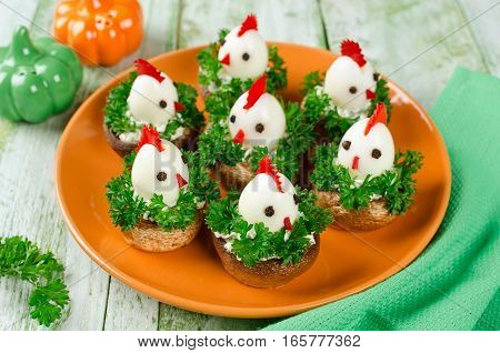 Funny chickens from eggs on the Easter table. Appetizer of mushrooms and quail eggs