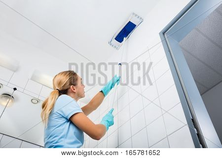 Cleaning Service Woman Cleaning The Ceiling Of The Bathroom With Mop At Home