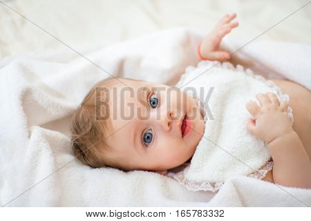 sweet happy little girl lying in bed