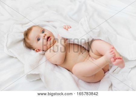 sweet happy little girl lying in bed