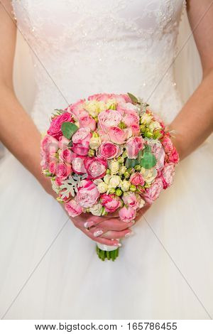Bride with bouquet of roses in her hands