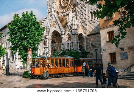 Port de Soller Mallorca Spain - May 26 2016: Old tram in Soller in front of medieval gothic cathedral. Landmark of Mallorca Spain