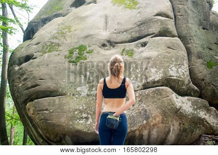 Young Woman With Climbing Equipment In Front Of A Stone