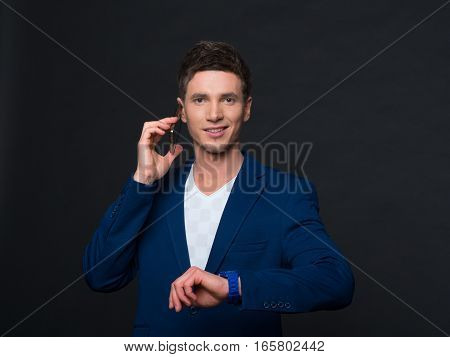 portrait of a young man on a gray background in a blue jacket.