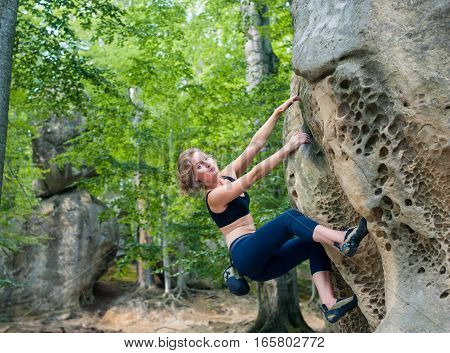 Young Woman Climbing On Large Boulders Outdoor