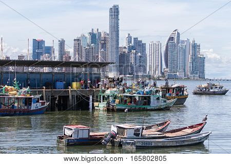 June 15, 2016 Panama City, Panama: small fishing boats floating on the water by the fish market with the modern downtown highrise buildings in the background