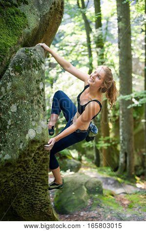 Young Woman Climbing On Large Boulders Outdoor
