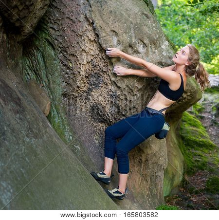 Young Woman Climbing On Large Boulders Outdoor