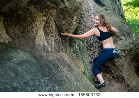 Young Woman Climbing On Large Boulders Outdoor
