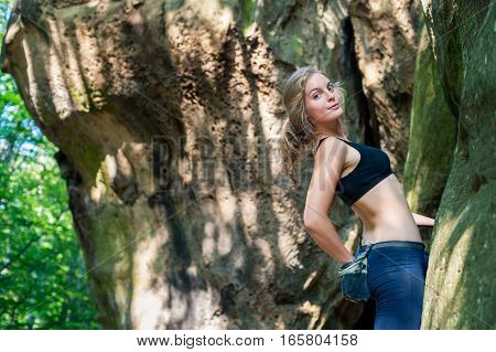 Young Woman Climbing On Large Boulders Outdoor