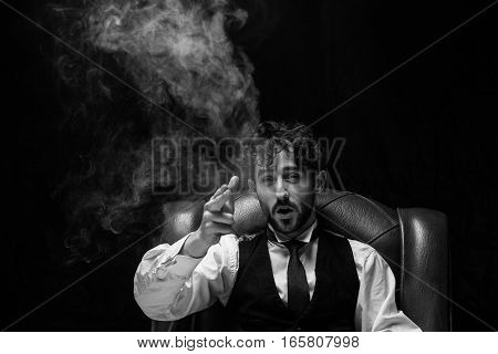 Businessman with smoking gun finger red. red chair on a black background