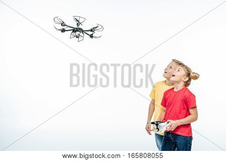 Happy kids playing with flying hexacopter drone isolated on white