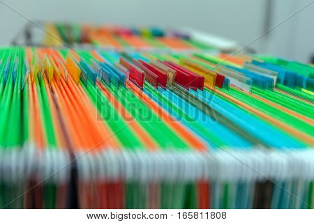 Abstract background of colorful hanging file folders in drawer. Stock photo