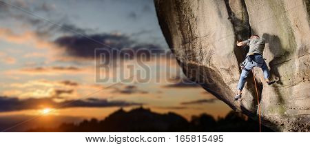Male Climber Climbing Big Boulder In Nature With Rope
