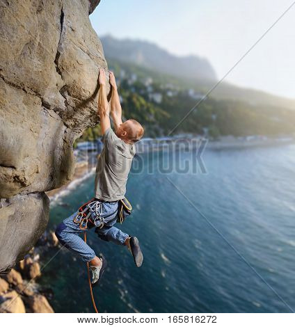Male Climber Climbing Big Boulder In Nature With Rope