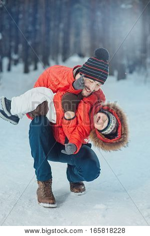 father holding the baby in his arms on the winter background