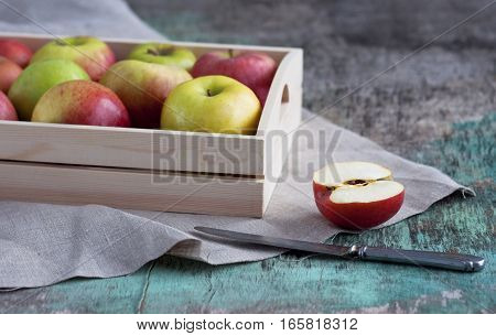 Fresh apples in a tray on a wooden background. Apples are red, green, yellow. Healthy Eating Vitamins Vegetarian Seasonal harvest.