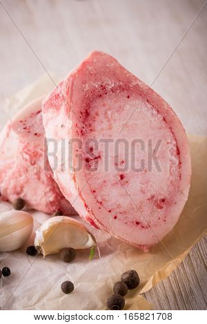 Two Marrowbone Pieces With Spice On White Wooden Board
