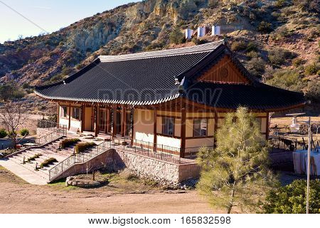 Buddhist Temple building surrounded by rural mountains creating a quiet and peaceful atmosphere taken at Tae Go Sah Zen Monastery in Tehachapi, CA
