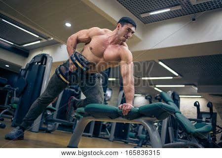 Man lifting weights. At the sports Hall. Man training. Sports. Hard Work. Gym