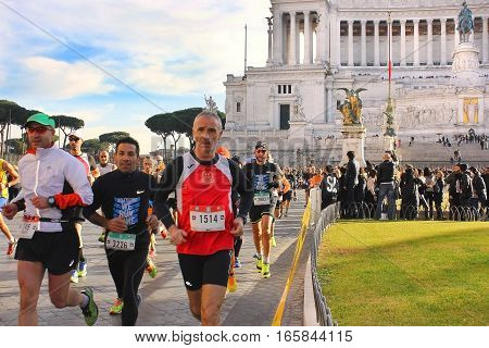 ROME, ITALY: December 31, 2016 : athletes participating in the Rome Marathon while crossing Piazza Venezia, in the background the famous Vittoriano monument on December 31, 2016, Rome, Italy