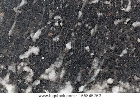 Snow slush on a paved road side.