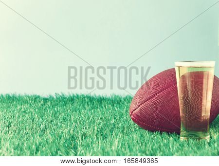 Vintage football over grass and beer glass