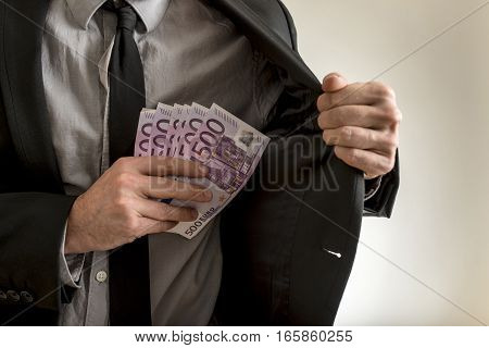Man Putting Euros Inside His Jacket Pocket