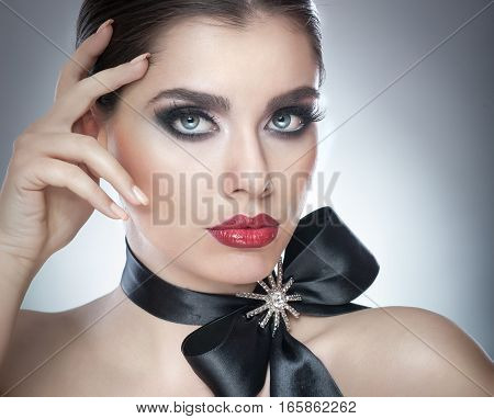 Hairstyle and Make up - beautiful female art portrait with black ribbon. Elegance. Genuine Natural brunette with ribbon - studio shot. Portrait of a attractive woman with beautiful eyes and red lips