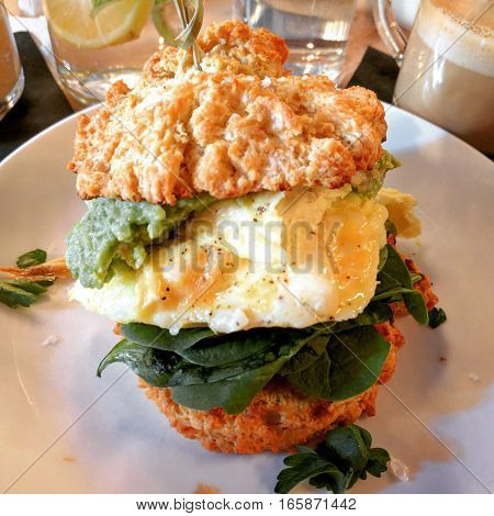 Scrambed eggs, avocado, baby spinach and tomato jam on buttermilk biscuits