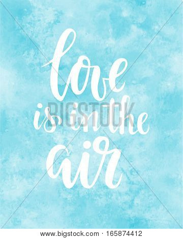 love is in the air Hand drawn creative calligraphy and brush pen lettering on blue watercolour background. design for holiday greeting card and invitation of the wedding Valentine's day and Happy love day