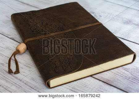 Classic Leather Bound Journal Book on a White Barn Board Floor Close Up