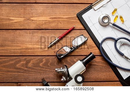 doctor workplace at wooden table with microscope in lab top view no one