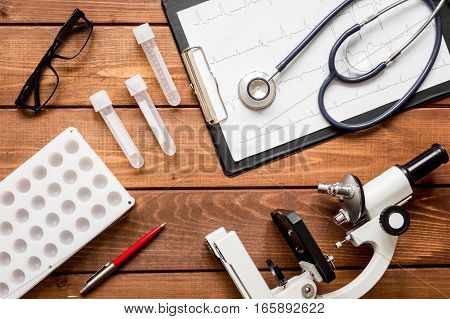doctor workplace at wooden table with microscope in lab top view no one