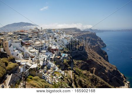 Santorini Greece -  13 August 2016: Scenic view of traditional cyclades white houses churches and blue domes in Fira village at the Santorini island in Greece