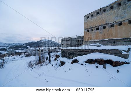 Exterior of old decayed abandoned prison in Kolyma in evening light