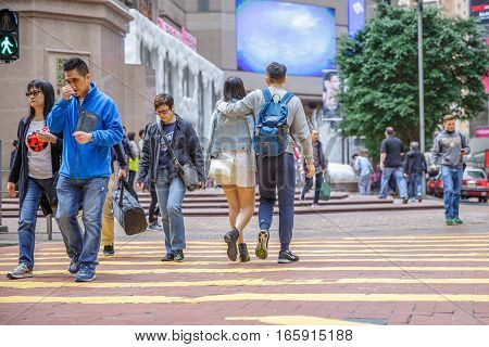 Hong Kong, China - December 6, 2016: Causeway Bay is one of the most attractive areas for tourists and business people and good for shopping. Asian happy couple crossing the Times Square intersection.