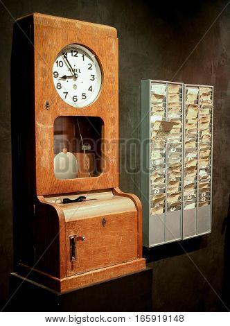 BERLIN GERMANY - 29 JANUARY 2005: A retro time clock with a rack of punch cards used to determine the hours worked by employees.