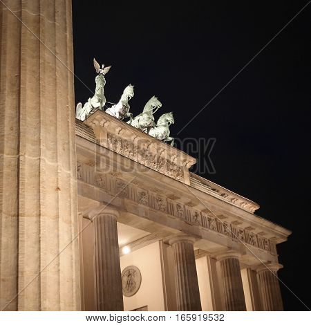 A night view of the Brandenburg Gate Berlin with focus on the familiar quadriga atop the monument.