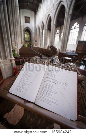SAFFRON WALDEN UK - JUNE 8 2006: A wide-angle view of the interior of St. Mary's Church Saffron Walden Essex UK with focus on the generic religious text on an elaborate lectern.