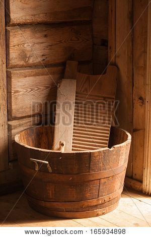 Old household equipment and machines. Wooden washboard and big bowl made of boards
