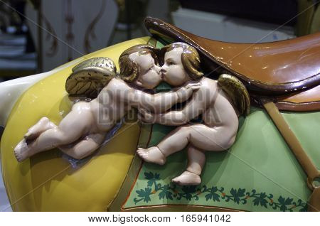 two wooden cupid  carvings with wings kissing