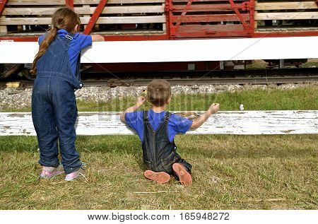 ROLLAG, MINNESOTA, Sept 1. 2016:Two unidentified children peer through a fence as they watch a passing freight train at the West Central Steam Threshers Reunion in Rollag, MN attended by 1000`s held annually on Labor Day weekend.