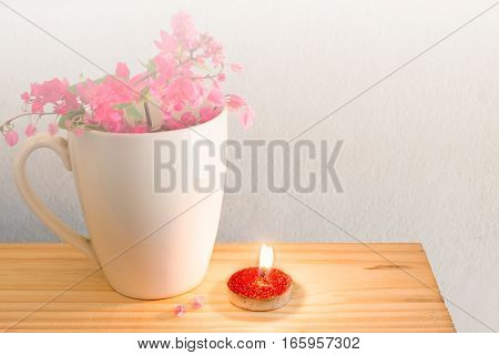 Red candle white mug coffee and the Antigonon leptopus flower.