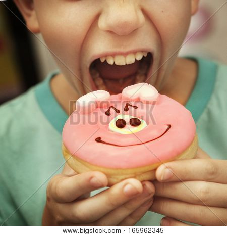 teen by eat doughnut with pig glaze close up
