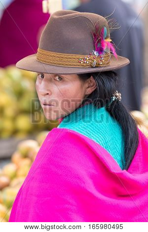 July 24, 2016 Alausi, Ecuador: portrait of an indigenous kichwa woman dressed traditionally wearing a feather decorated felt hat outdoors