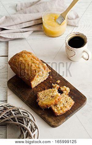 Glazed applesauce oatmeal sliced loaf cake on a white marble background. Ideal healthy breakfast with coffee